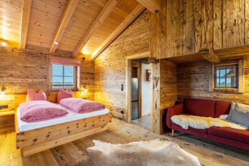 a bedroom in a log cabin with a bed and a couch at Chalet Bergliebe in Brilon