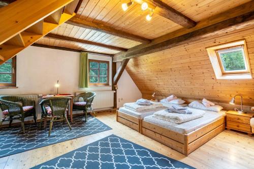 a bedroom with two beds and a table and chairs at Ferienhaus Henneberg in Johanngeorgenstadt