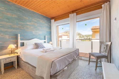 a bedroom with a bed and a large window at Apartamento Noenil in L'Estartit