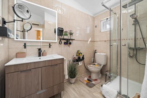a bathroom with a sink and a shower and a toilet at Casa Gudrun in Praia do Carvoeiro