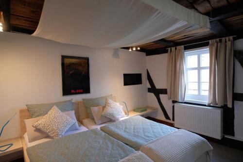 a bedroom with a bed and a couch and a window at Beim Bildhauer Karl F in Trendelburg
