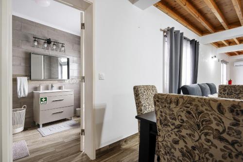 a bathroom with a sink and a vanity with a mirror at Windmill Beach House in Ribeira Grande