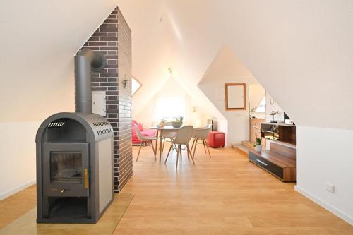 a living room with a fireplace and a dining room at Dinkelbach Landhaus 1 B in Lindau-Bodolz