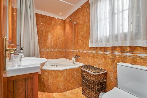 a bathroom with a sink and a tub and a toilet at Casa Murillo in Nerja