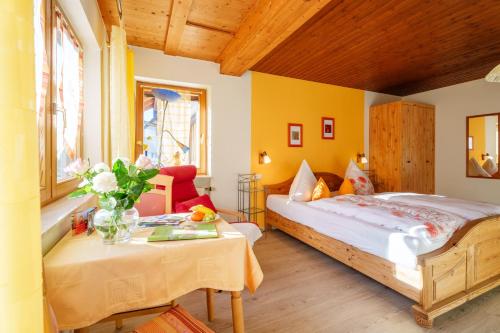 a bedroom with a bed and a table at Pension Haus Rose in Oberharmersbach