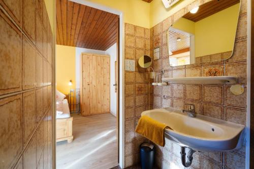 a bathroom with a sink and a mirror at Pension Haus Rose in Oberharmersbach