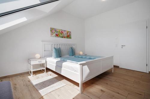 a white bedroom with a bed and a table at Ferienwohnung Auszeit in Kargow