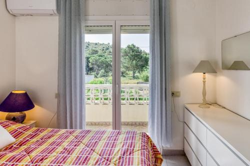 a bedroom with a bed and a balcony at Casa 3 Dormitorios Con Piscina in L'Escala