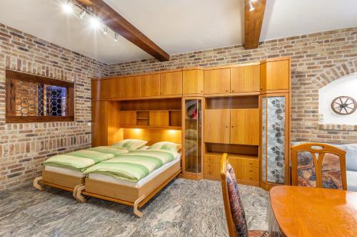 a bedroom with two beds and a brick wall at Ferienwohnungen Bunge in Krostitz