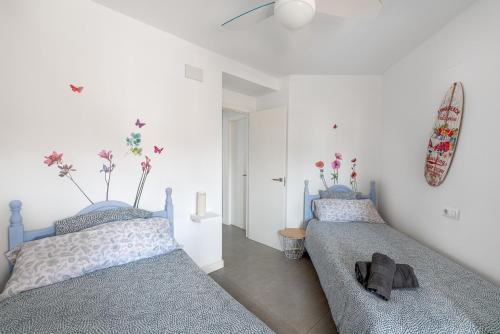 two beds in a room with white walls at Amplio Canet in Canet de Berenguer