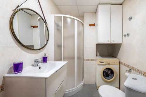 a bathroom with a sink and a toilet and a mirror at Amplio Canet in Canet de Berenguer