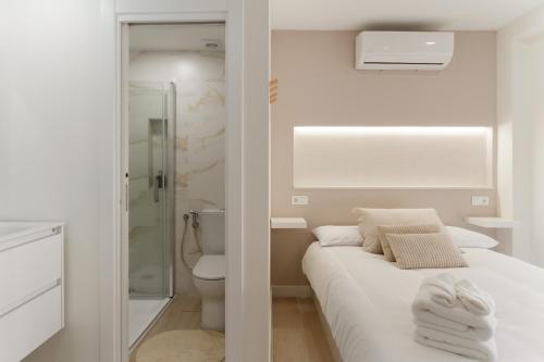 a white bathroom with a bed and a shower at Cala Sol - few steps from the beach in La Cala de Mijas