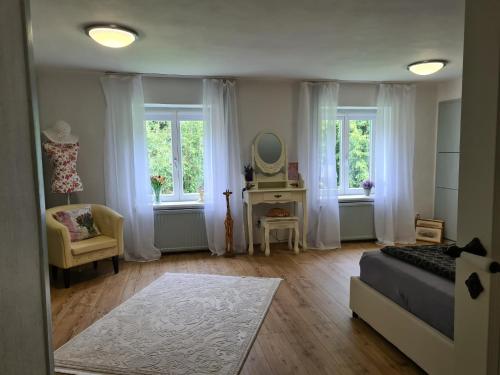 a bedroom with a bed and a mirror and windows at Ferienwohnung Haloi in Torsballig