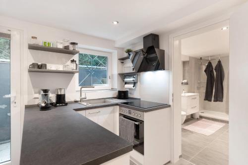 a white kitchen with a sink and a stove at Hochwertige Ferienwohnung Ötigheim in Ötigheim
