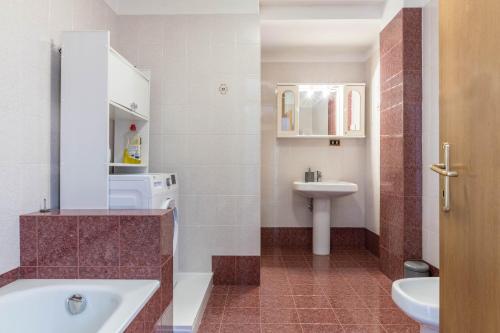 a bathroom with a tub and a sink at Appartamento dorsino in Dorsino