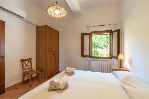 a bedroom with a large white bed and a window at Villa Zagara in Partinico