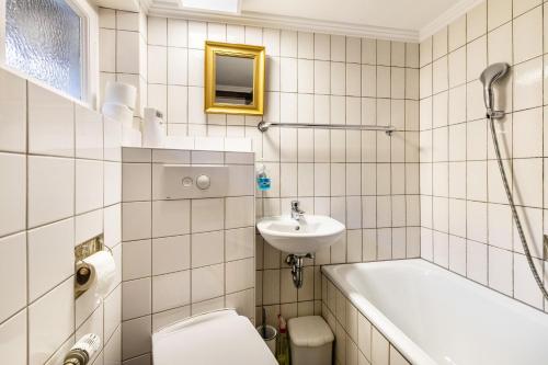 a bathroom with a sink and a toilet and a bath tub at Panoramaferienhaus Sorpesee, 120qm in Sundern
