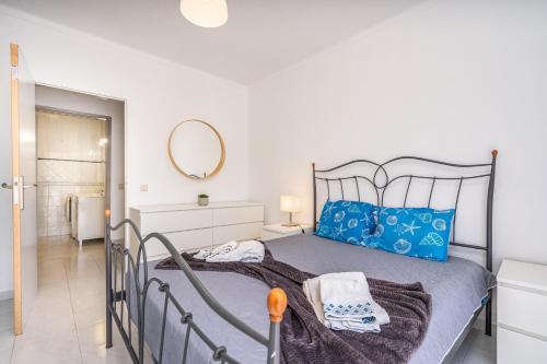 a bedroom with a bed with blue pillows and a mirror at Isabel apartment in Carvoeiro