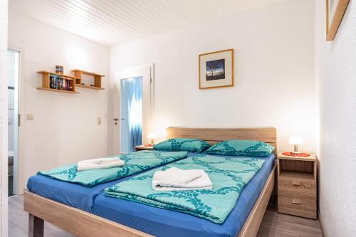 a bedroom with a bed with blue sheets and towels at Prerow Am Deich - Ferienwohnung 1 in Prerow