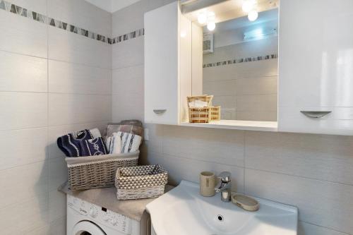 a white bathroom with a sink and a mirror at Casa di Ali in Imperia