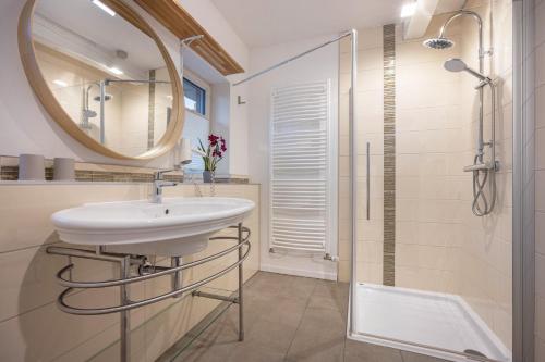 a bathroom with a sink and a shower and a mirror at Ferienwohnungen in Neufeld in Neufeld