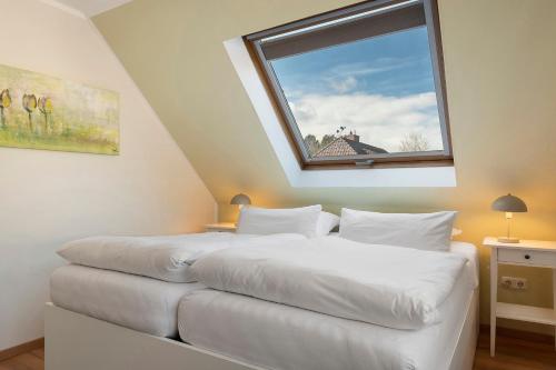 two beds in a room with a window at Ferienhaus Jadeblick I I in Dangast
