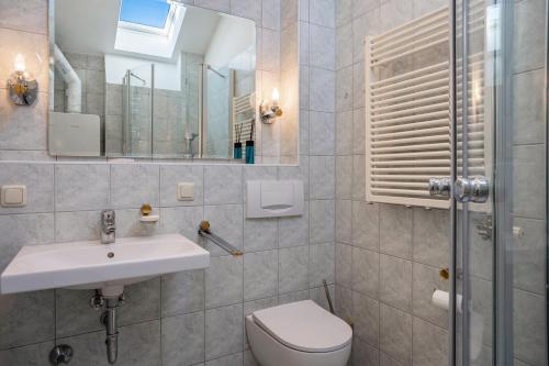 a bathroom with a sink and a toilet and a mirror at Haus Ostseesonne in Baabe