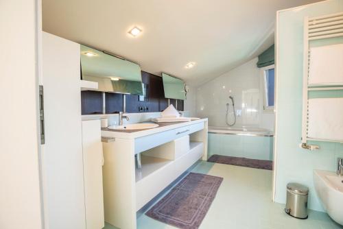a white bathroom with a sink and a tub at Tubris Living in Sand in Taufers