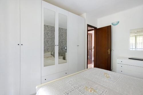a bedroom with white walls and a bed with white cabinets at Da Ercolino in Pitelli