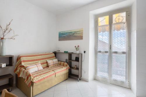 a white bedroom with a bed and a window at Da Ercolino in Pitelli