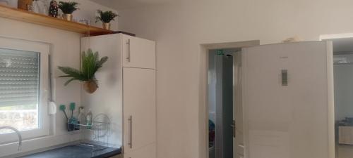 eine Küche mit einem weißen Schrank und einem Fenster in der Unterkunft Brač Milna in Milna