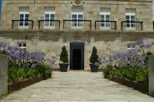 a building with purple flowers in front of it at Hotel Palacio Urgoiti in Mungia