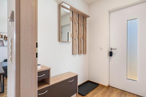 a bathroom with a vanity and a mirror and a door at Apartments Winder 1 in Lustenau