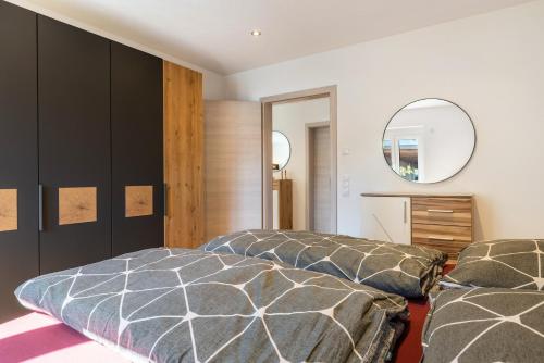 a bedroom with two beds and a mirror at Apartments Winder 1 in Lustenau