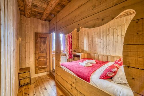 a bedroom with a bed in a wooden wall at Anna-purna in Arâches-la-Frasse