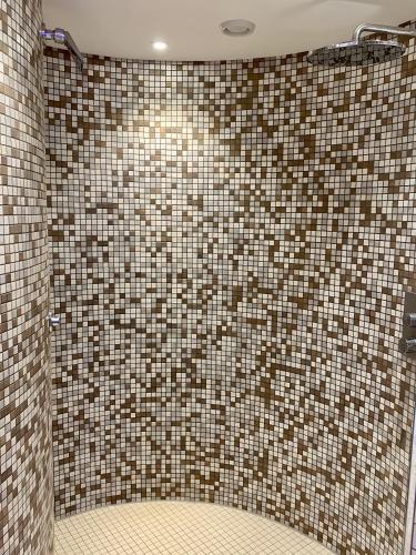a bathroom with a shower with a tiled wall at 208 im Lord Nelson in Cuxhaven