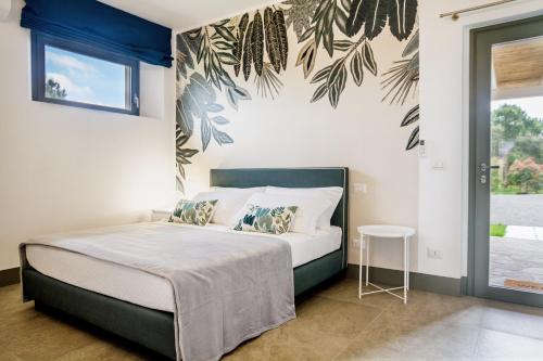 a bedroom with a bed with a blue and white wall at Casale Lorenzo Appartamenti in Orbetello