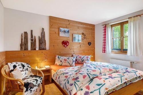 a bedroom with a bed and a chair at Haus Verdandi in Sibratsgfäll
