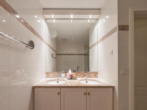 a bathroom with two sinks and a large mirror at Ferienwohnungen Hensler in Lindau
