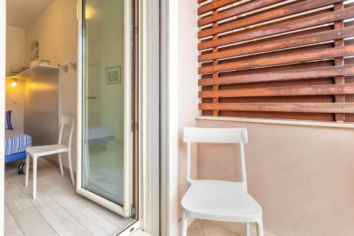 a room with two white chairs and a window at Villafranca in Alghero