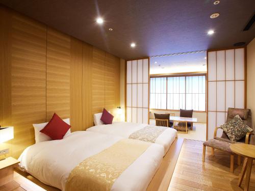a bedroom with a large bed and a table and chairs at Kyoto Hot Spring Hatoya Zuihokaku Hotel in Kyoto