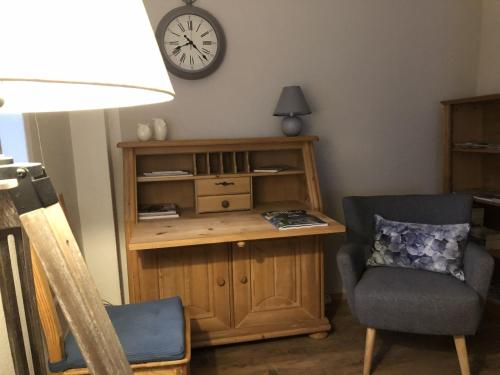 a room with a desk and a chair and a clock at Logierhaus An der Truse in Brotterode
