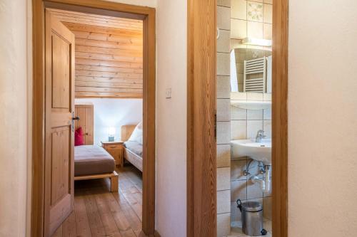 a hallway with a bathroom with a sink and a bedroom at Ronacherhof Apt Ringelblume in Collalbo