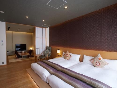 a bedroom with a large bed and a television at Kyoto Hot Spring Hatoya Zuihokaku Hotel in Kyoto