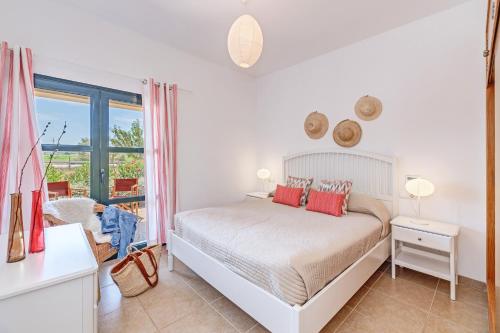 a white bedroom with a bed and a window at Finca Sa Pradera in Palma De Mallorca