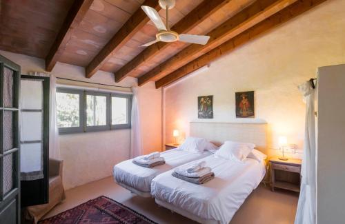 a bedroom with two beds and a ceiling fan at Baix d' Or in Felanitx