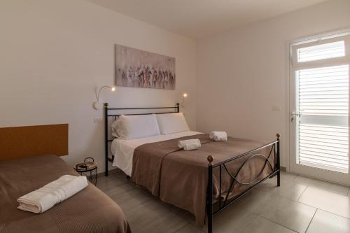 a bedroom with a bed and a window at Villa Vani - Appartamento 1 in Marina di Ragusa