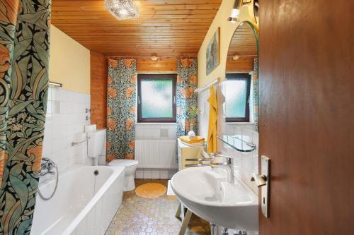 ein Badezimmer mit Waschbecken, Badewanne und Toilette in der Unterkunft Ferienwohnung Schwalm - Aue in Neuental