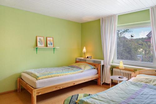 ein Schlafzimmer mit zwei Betten und einem Fenster in der Unterkunft Ferienwohnung Schwalm - Aue in Neuental