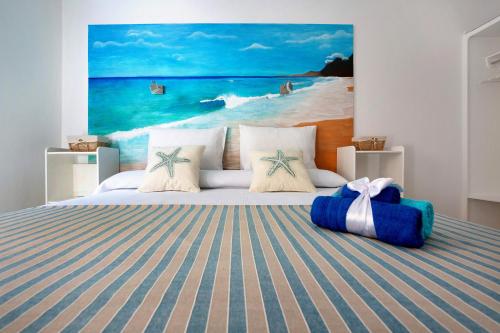 a bedroom with a bed with a painting of the ocean at Holidays Maxorata Relax in Gran Tarajal